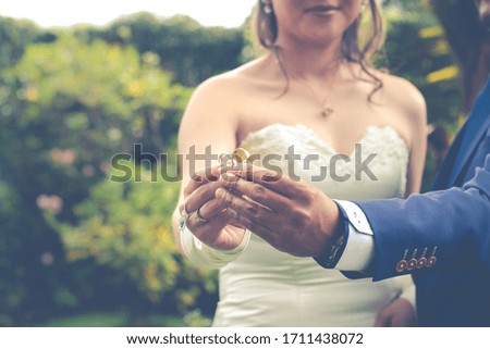 Wedding couple holding rings on hand