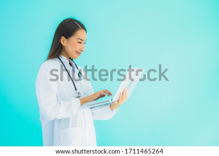 Portrait beautiful young asian doctor woman with laptop for use in clinic or hospital on blue isolated background