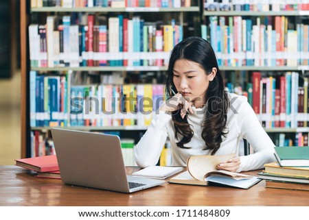 Young beautiful asian student study in the school library and using laptop for online learning.e-Learning education concept.Back to school