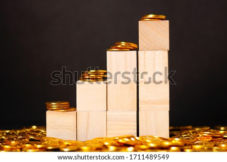 Wooden bar chart and gold coins