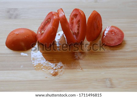 Sliced ripe red tomatoes on a wooden texture background