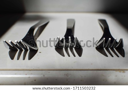 Three forks with a shadow on a concrete background