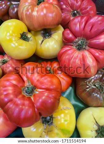 Different colors of heirloom tomatoes on display at a local market.