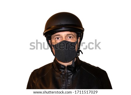 Isolated on white background man motorcyclist in a helmet and a mask that protects against coronavirus. Black jacket, protection and biker gloves