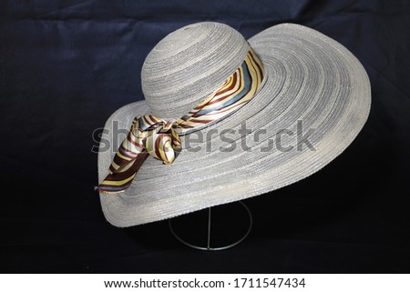 Wide hat with ribbon decoration on it