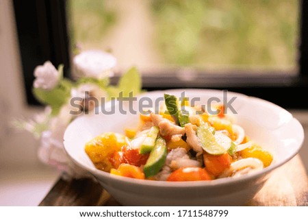 fried pork with pineapple in sweet and sour sauce on wooden plate,thai food.focus around front of picture-image.