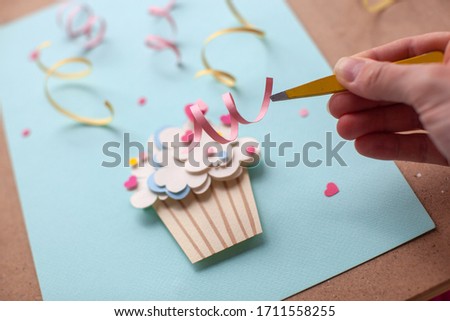 Paper cutting cupcake on blue background. Handmade art work. Colorful sprinkles, dot and star, for your birthday card design. 