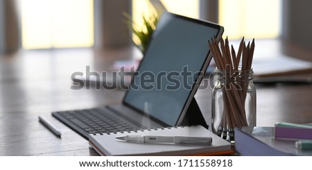 Office equipment on home working desk with tablet, pencil, pen and notebook. Royalty-Free Stock Photo #1711558918