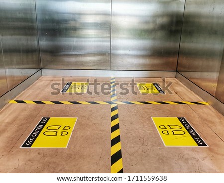 Selective focus to floor of passenger lift with standing marker for social distancing to avoid spreading coronavirus ( Covid-19 ). Location or distance concept. Idea for COVID-19 outbreak.