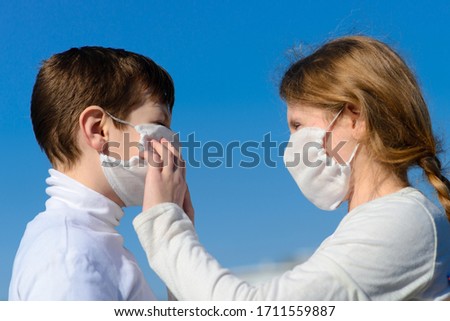 Children in a city park in a medical mask. Walking on the street during the quarantine period of the coronavirus pandemic in the world. Precautions and teaching children