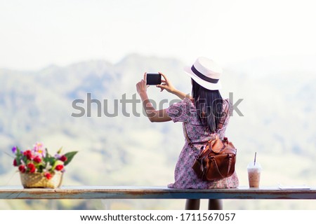 Enjoying time at balcony. Beautiful young woman drinking ice coffee and take a picture. Happy in the morning.