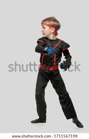 Young boy training karate martial art isolated on light gray background