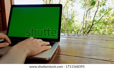 Over the shoulder shot of female hands typing on laptop computer keyboard. Work at home, freelancer concept, job project, writing, web communication, digital nomad, green screen