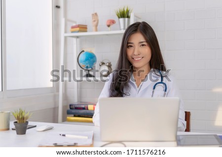 Asian female doctor work at hospital office desk giving patient convenience online service advice, women smiling write a prescription to order medical, health care and preventing disease concept 