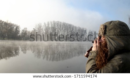 Tourist woman making photos with a vintage camera in a winter landscape. Salamanca, Spain.