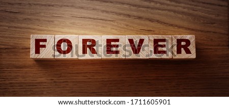 FOREVER word on wooden cubes on wooden Floor. Eternal love or trustworthy business longterm relationship concept.