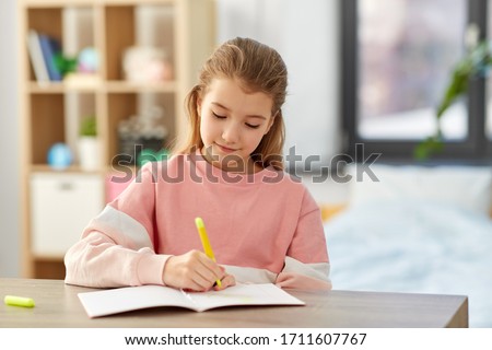 childhood, creativity and hobby concept - creative little girl with notebook and marker drawing at home