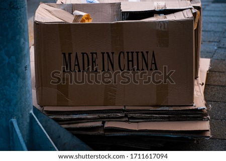 Color photo of a discarded cardboard box with "MADE IN CHINA" written in large print. 