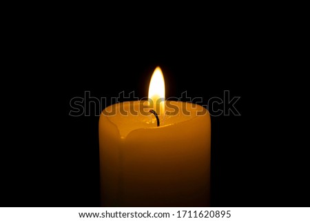 Close up of orange wax candle flame on a dark background Royalty-Free Stock Photo #1711620895