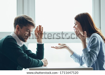 Woman and man discussing an important topic at the table Royalty-Free Stock Photo #1711647520