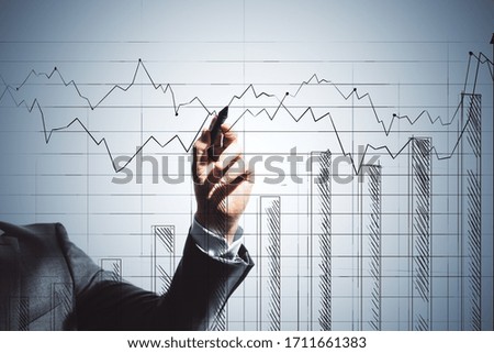Businessman hand drawing glowing stock chart on virtual screen. Trade and analysis concept. Close up