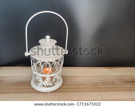 Vintage lantern with an orange candle on the table with black backdrop. Concept - Ramadan kareem holiday celebration. Royalty Free Stock photo