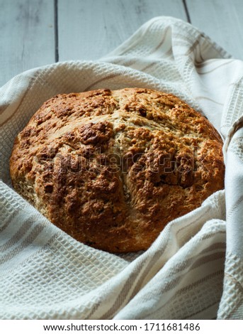 Homemade Fresh Traditional Irish Soda Bread with dried cranberries and pumpkin seeds on a white cotton kitchen towel Royalty-Free Stock Photo #1711681486