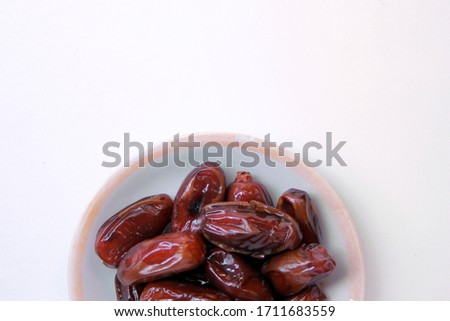 Dried Date Fruits in a dish top view white isolated background copy and text space ready