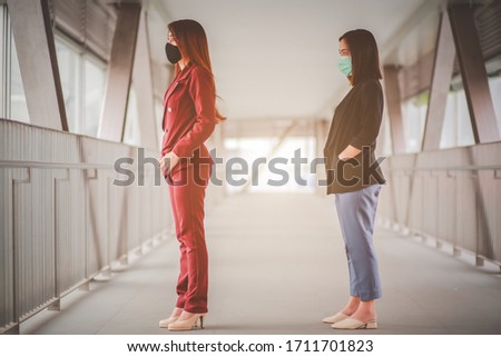 Two woman Asian people standing distance of 1 meter from other people keep distance protect from COVID-19 viruses and people social distancing for infection risk. Royalty-Free Stock Photo #1711701823