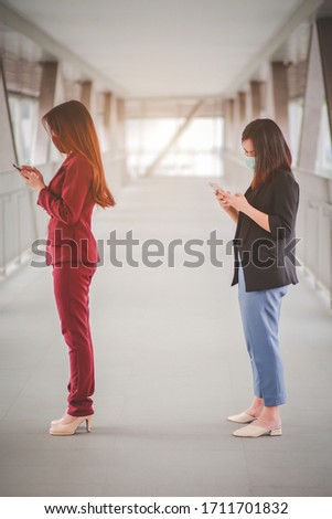 Two woman Asian people standing distance of 1 meter from other people keep distance protect from COVID-19 viruses and people social distancing for infection risk. Royalty-Free Stock Photo #1711701832
