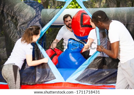Adult fun friends box in huge boxing gloves in an amusement park