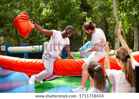 Fun wrestling with pillow in an amusement park on a summer sunny day