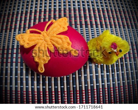 Red Easter egg and a cute little yellow chick. Colorful Easter eggs - part of the passover meal. Easter (Bright Sunday of Christ) is the oldest and most important Christian holiday. 