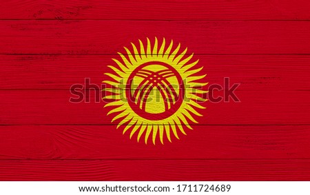 Kyrgyzstan flag on a wooden texture. Wood texture, planks Wooden texture background flag. Flag painted with paints on wood