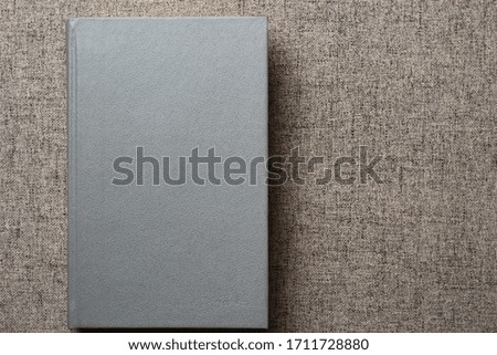 Gray book on the sofa with place for an inscription or text