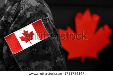 Canada Day. Flag of Canada on the military uniform and red Maple leaf on the background. Canadian soldiers. Army of Canada. Canada leaf. Remembrance Day. Poppy day. 