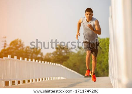 The silhouette of young men running and exercising at sunset with the sun in the background, colorful sunset sky