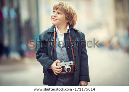 Little boy with a camera on the street
