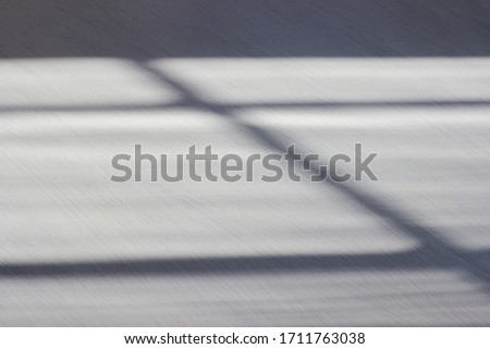 Abstract shadow background in the form of horizontal and vertical lines on a white wooden background. Trend hard shadows