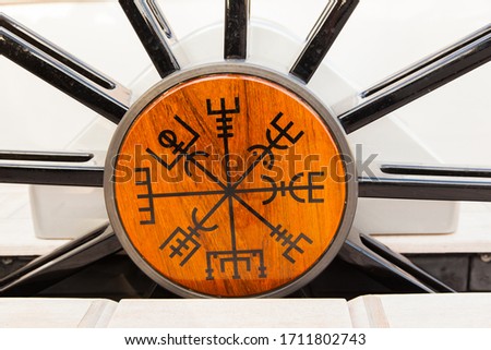 Unusual scandinavian symbols and signs on the helm of a sailing yacht. Viking runes on a sailing yacht.
