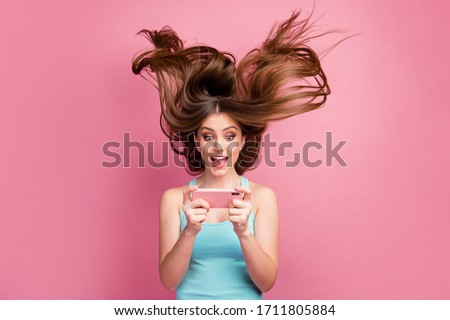 Portrait of nice attractive lovely charming funny focused cheerful cheery straight-haired girl using cell having fun free time ideal silky hair flying isolated on pink pastel color background