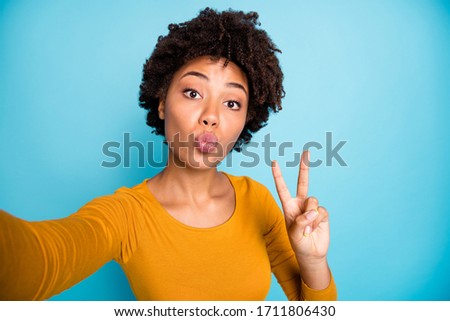 Self-portrait of her she nice attractive lovely sweet cheerful cheery wavy-haired girl showing v-sign having fun sending you air kiss isolated over bright vivid shine vibrant blue color background