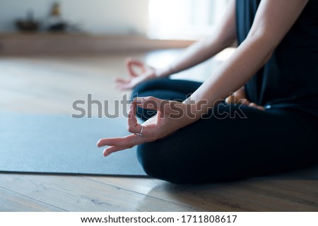 Woman meditating or doing yoga sitting on the mat cold blue tone Royalty-Free Stock Photo #1711808617