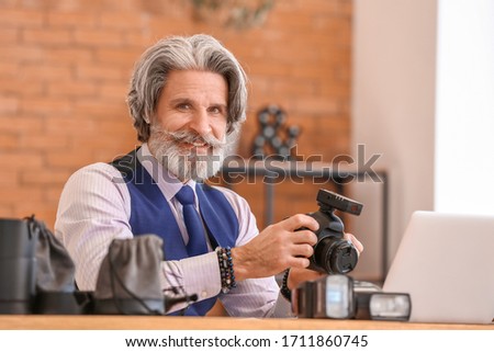 Senior photographer working at table in studio