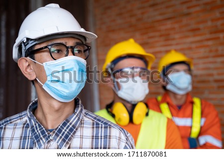 Industrial engineering team wears a COVID 19 protective mask. Workers wear a quarantine mask to prevent the spread of Covid 19 by wearing a face mask. Coronavirus disease. Royalty-Free Stock Photo #1711870081