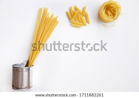 Pasta in a tin on a white background. Food supplies at home during the quarantine period. Food delivery. Traditional Italian food.Long-term storage products.