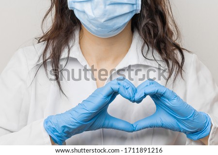Stop SARSCoV, virus 2020 , MERS-CoV, chinese virus COVID-19. Womens hand in blue medical gloves show heart sign. Concept of protection against HIV. Doctor in blue medical gloves and protective mask.