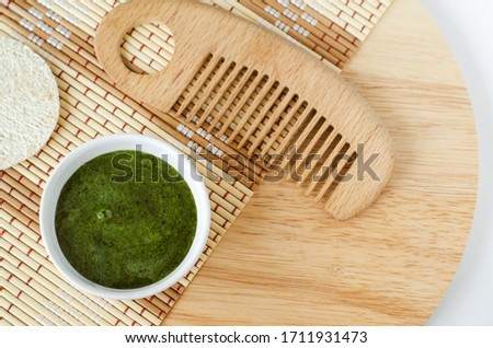 Diy green mask (scrub) with seaweed extract (or green tea) and wooden hair comb. Ingredients for preparing homemade cosmetics. Natural beauty treatment recipe, zero waste concept. Top view, copy space Royalty-Free Stock Photo #1711931473