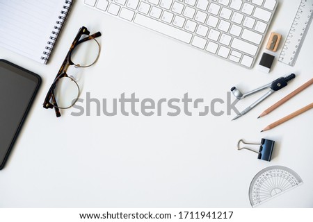 Top view table desk of office architect pencil, compasses tool, ruler, rubber, protractor grid, sharpener, glasses, smartphone, keyboard with copy space background.