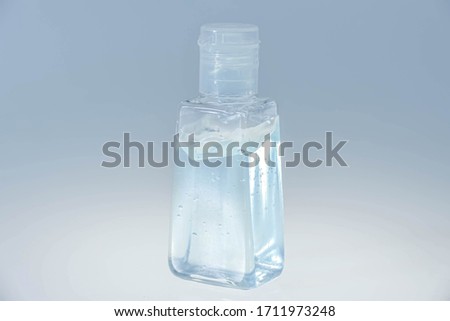 A small clear plastic bottle for carrying containing hand sanitizer.